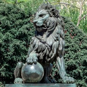 lion statue with paw on ball