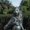 lion statue with paw on ball